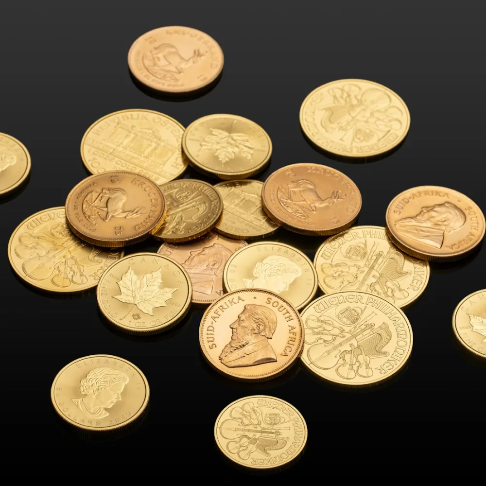 Monede de investiție din aur, printre care Krugerrand, pe fundal negru